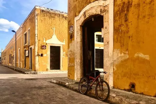 rue de la ville jaune de Izamal avec un vélo en premier plan