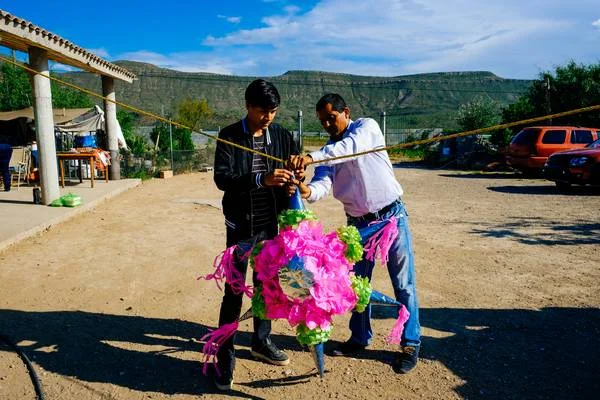 deux hommes accrochant une pinata à une corde