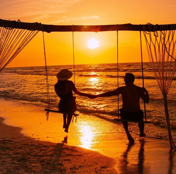 Couple sur une balançoir à regarder un coucher de soleil