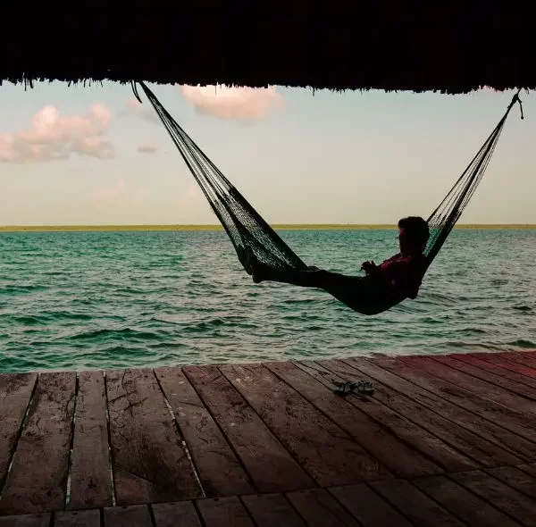 Homme dans un hamac au bord de la lagune de bacalar