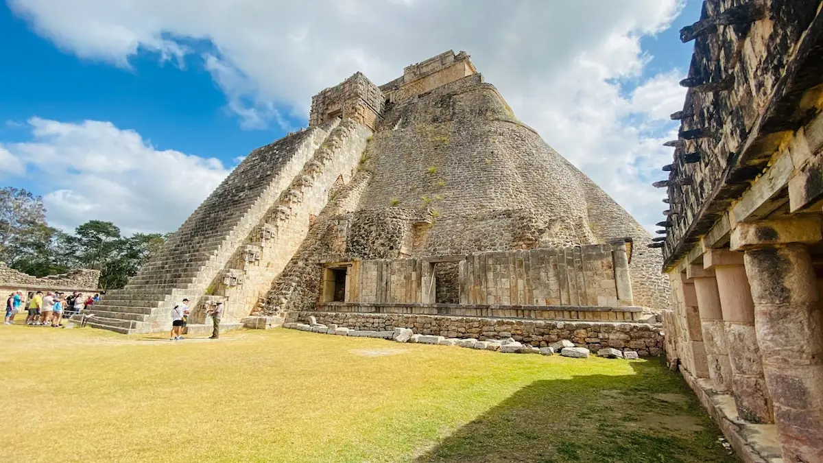 Vue d'ensemble de la Pyramide du Magicien à Uxmal avec ses contours arrondis et son imposant escalier.