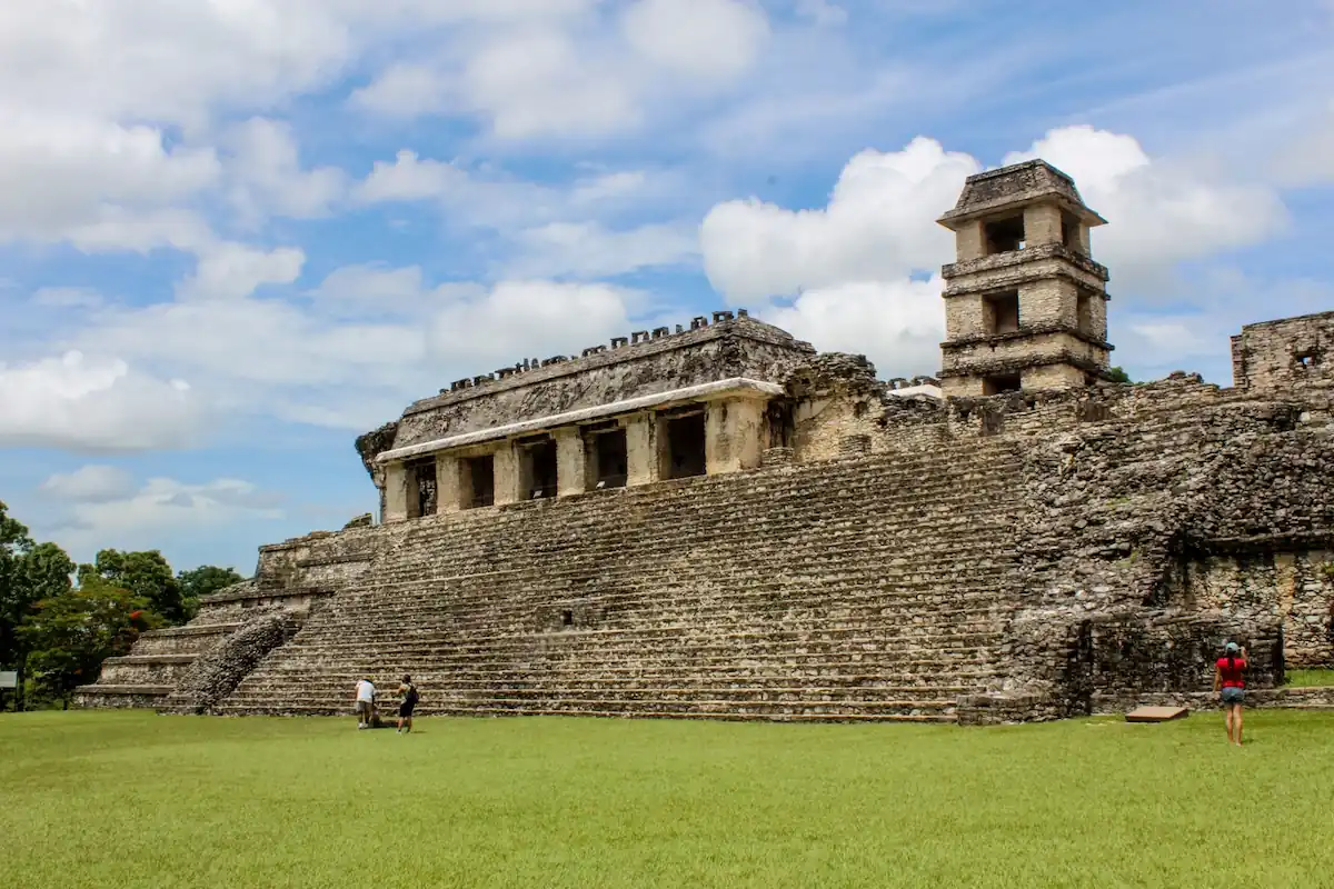Grande structure en pierre du Palais de Palenque surmontée de sa tour à quatre niveaux sous un ciel nuageux.