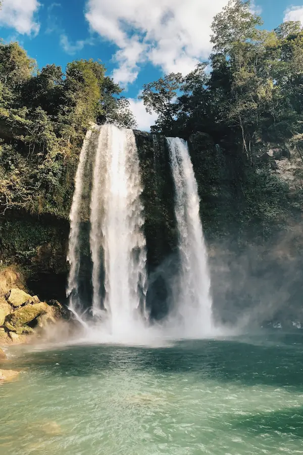 Impressionnante chute d'eau de Misol-Ha plongeant dans un bassin vert entouré par la jungle tropicale.
